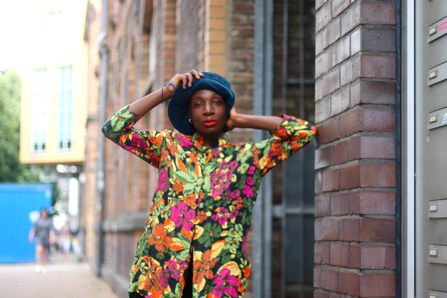 Female black model showcases a vibrant silk blouse with a traditional qipao-inspired collar, button-down front, and flowing long sleeves, exuding effortless, artful sophistication.