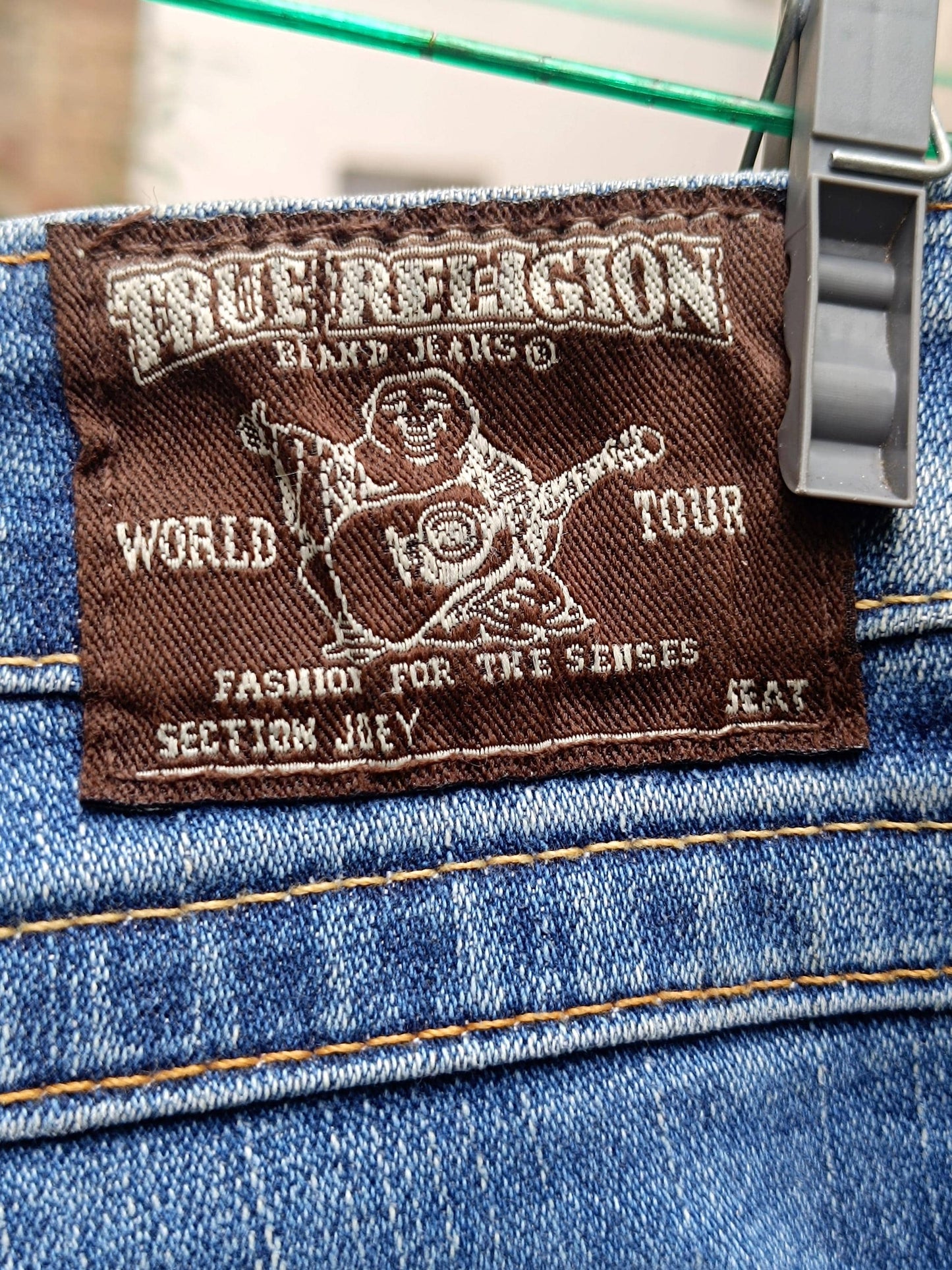 Close up of the brand tag of a Blue "True Religion' light blue women's jeans