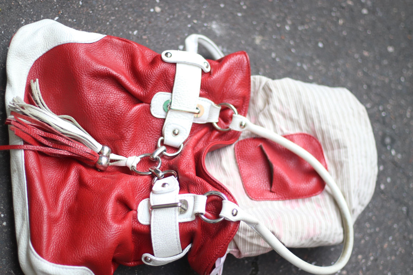 Vintage red bag with white accents from the early 2000s photographed on a graphite floor. The lining is also displayed
