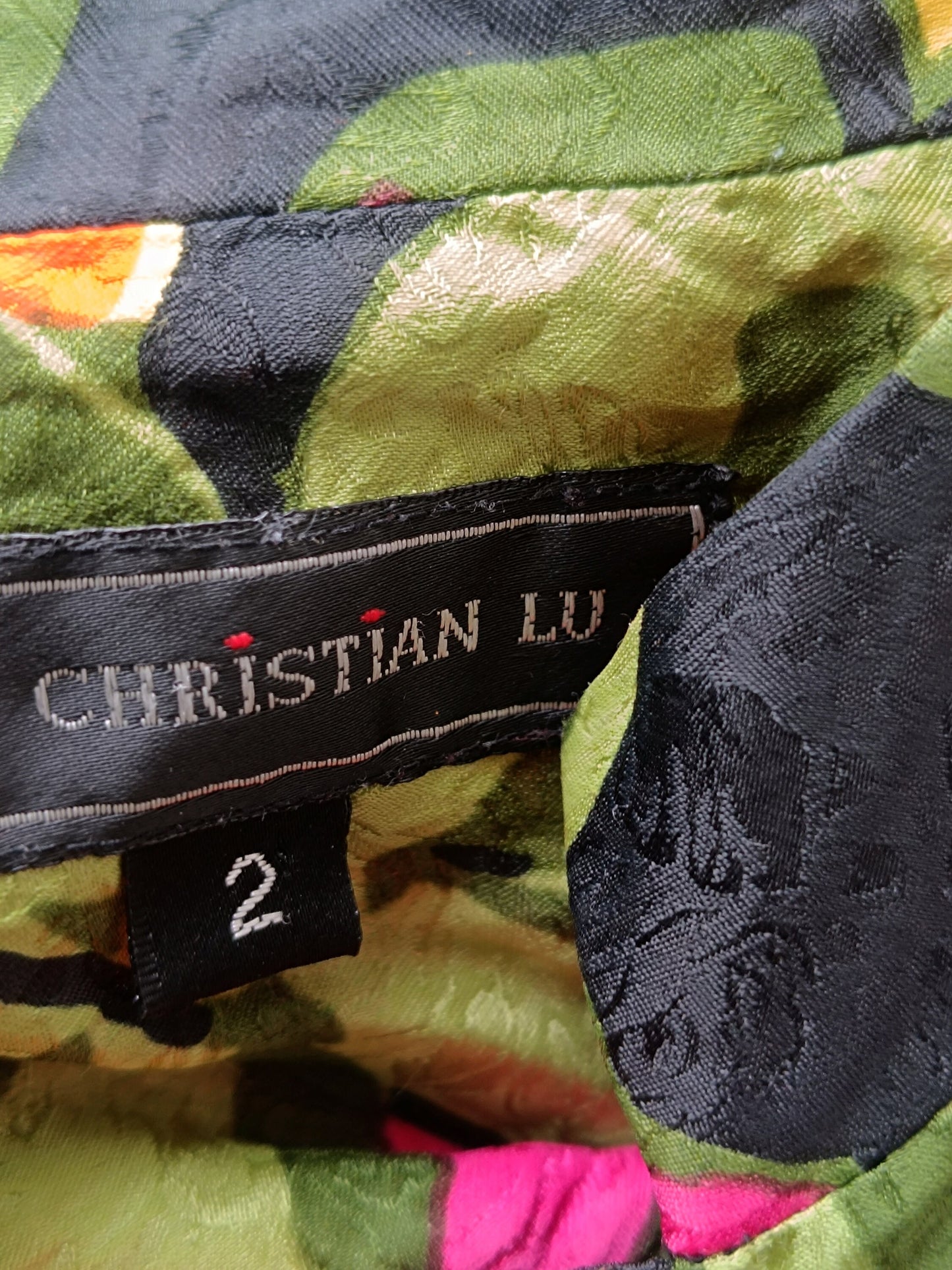 A closeup of a vintage Christian Lu silk blouse to show the brand tag and size detail