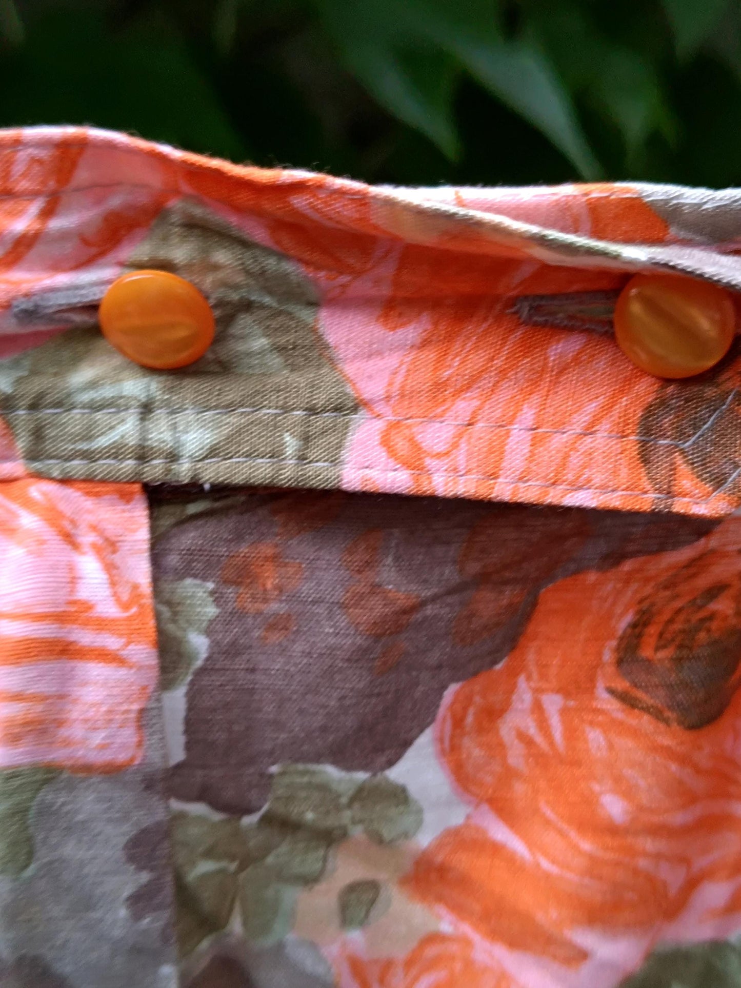 Close-up image of an 80s Floral Skirt. The image focuses on the buttons on the Vintage Orange design