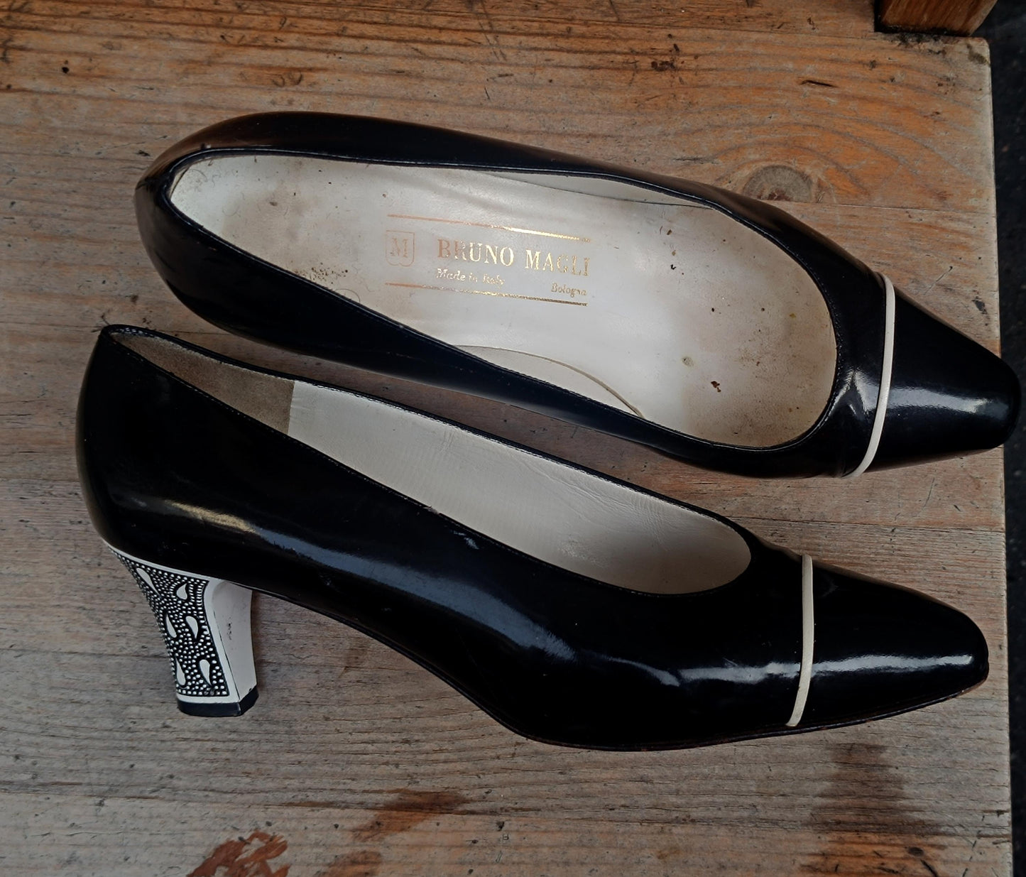 Overhead shot of vintage black and white patent pumps from the 80s, highlighting the pointed toe and sleek silhouette.