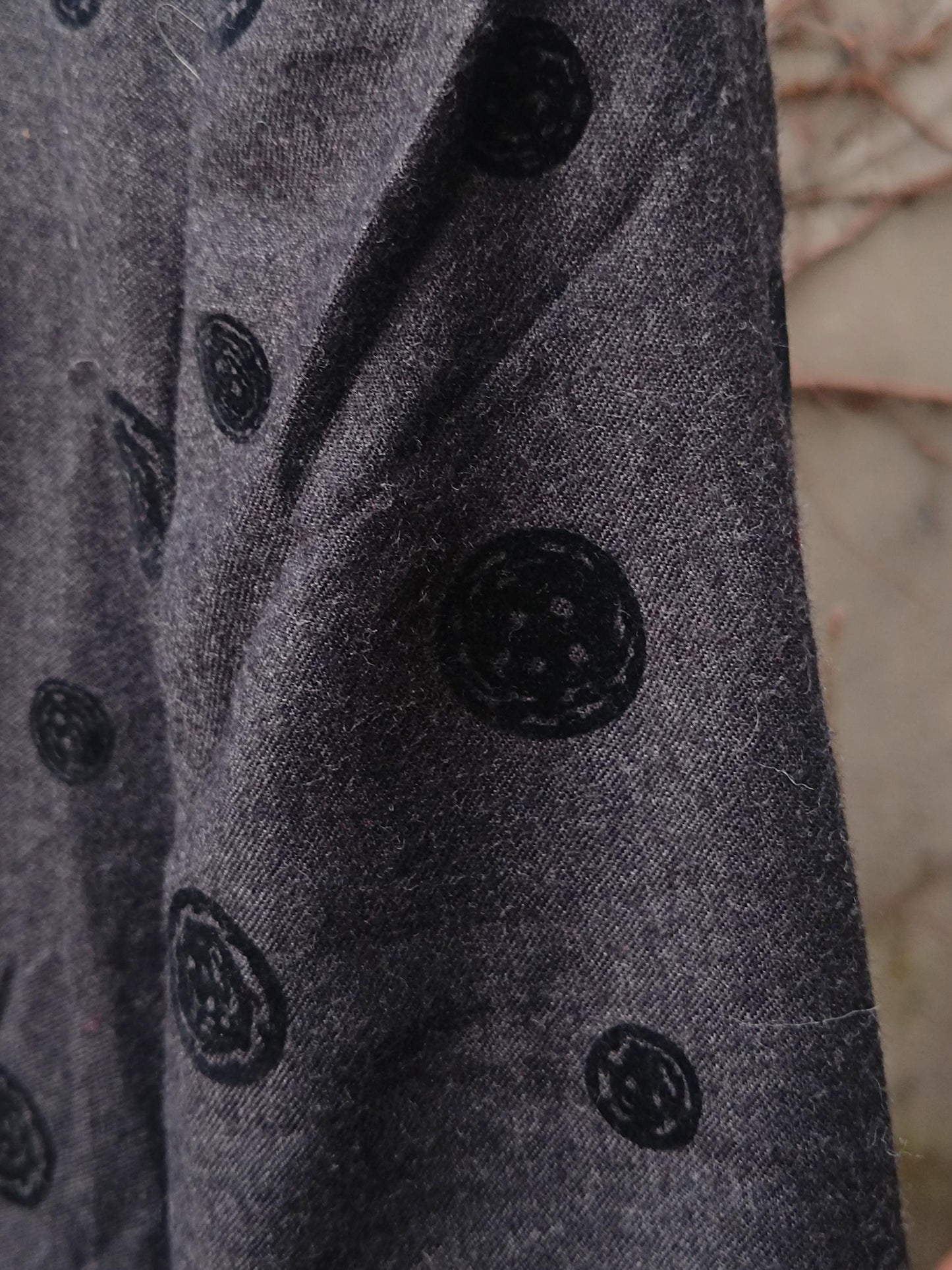 Close-up of a vintage gray and black polka dotted blazer showing the texture of the fabric