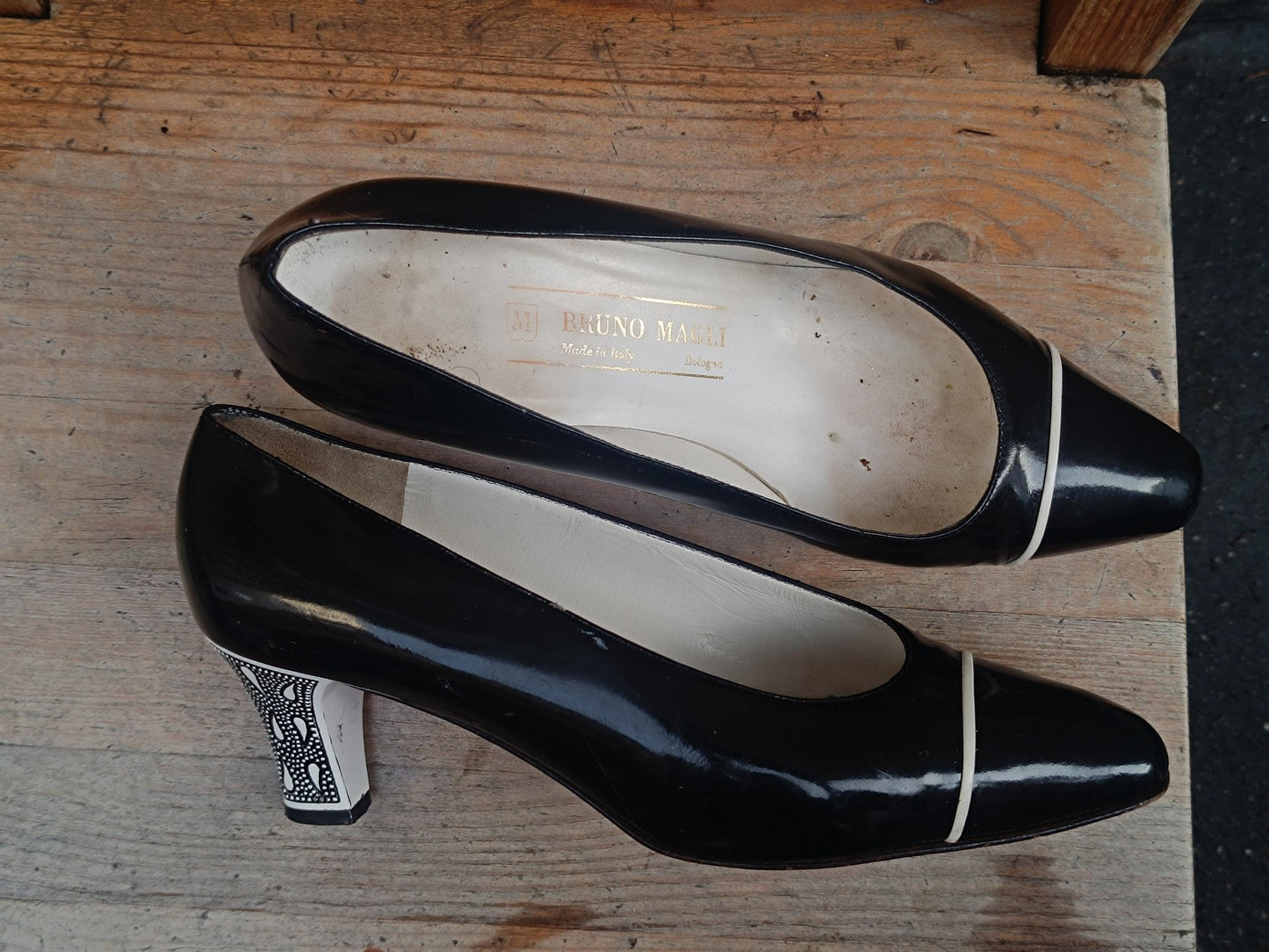 Glossy black vintage heels from the 90s with sculptural shape and subtle white detailing, ideal for office or evening wear.