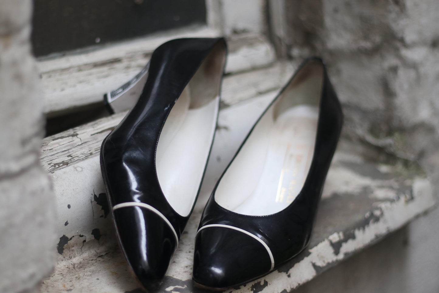 Detail shot of 80s black and white Retro designer pumps by Bruno Magli photographed against a minimalist white background.