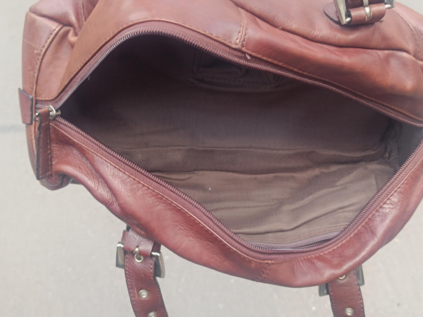 The inside of a 90s structured leather bag in rich brown, minimal and elegant with top handles.