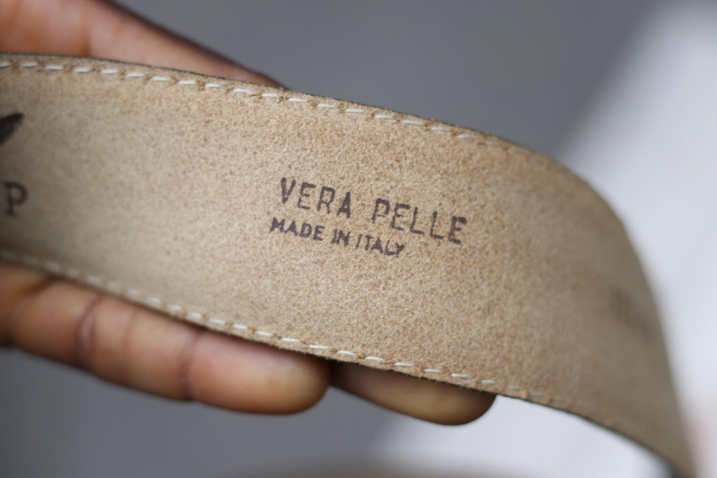 Close-up of the light brown leather belt interior, showing the embossed stamp "VERA PELLE MADE IN ITALY" as a mark of genuine leather quality.