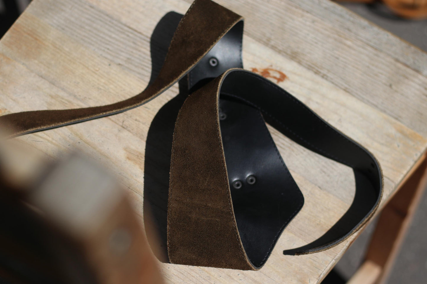 Detailed view of a the lining of a traditional Austrian belt in brown leather with distinctive brass leaf decorations