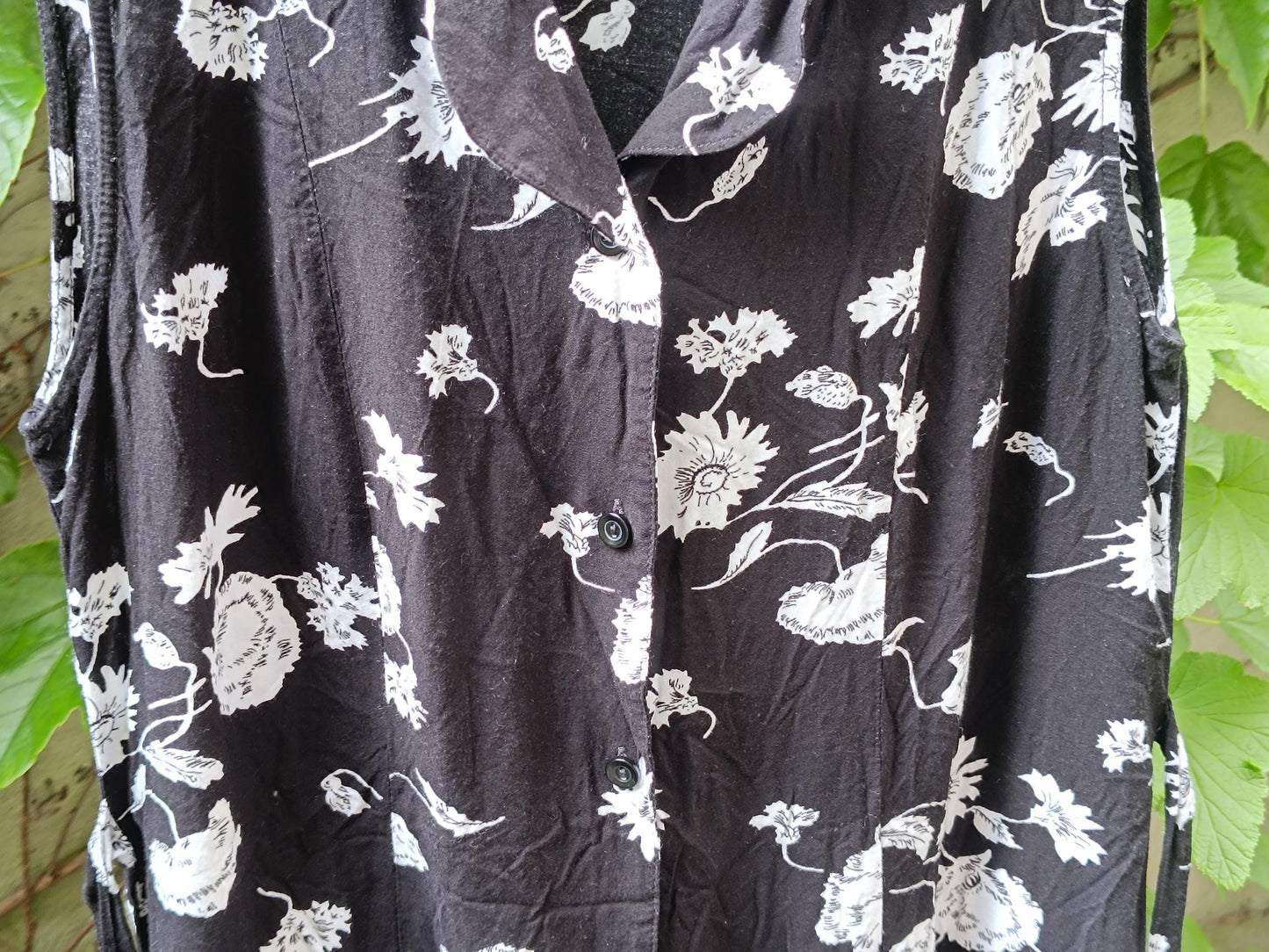 close-up of the black fabric of the dress, highlighting the white floral patterns and the texture of the material.