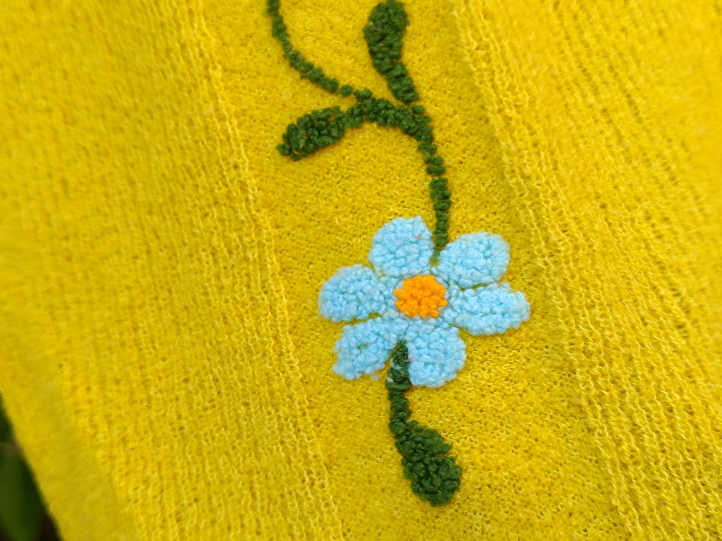 close up image of the vertical floral embroidery on a vintage yellow short sleeved top from the 70s