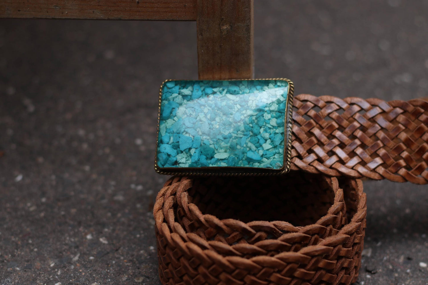 The turquoise buckle positioned on top of the coiled braided vintage leather belt. The handmade boho belt is perfect for adding a retro touch to summer dresses and skirts