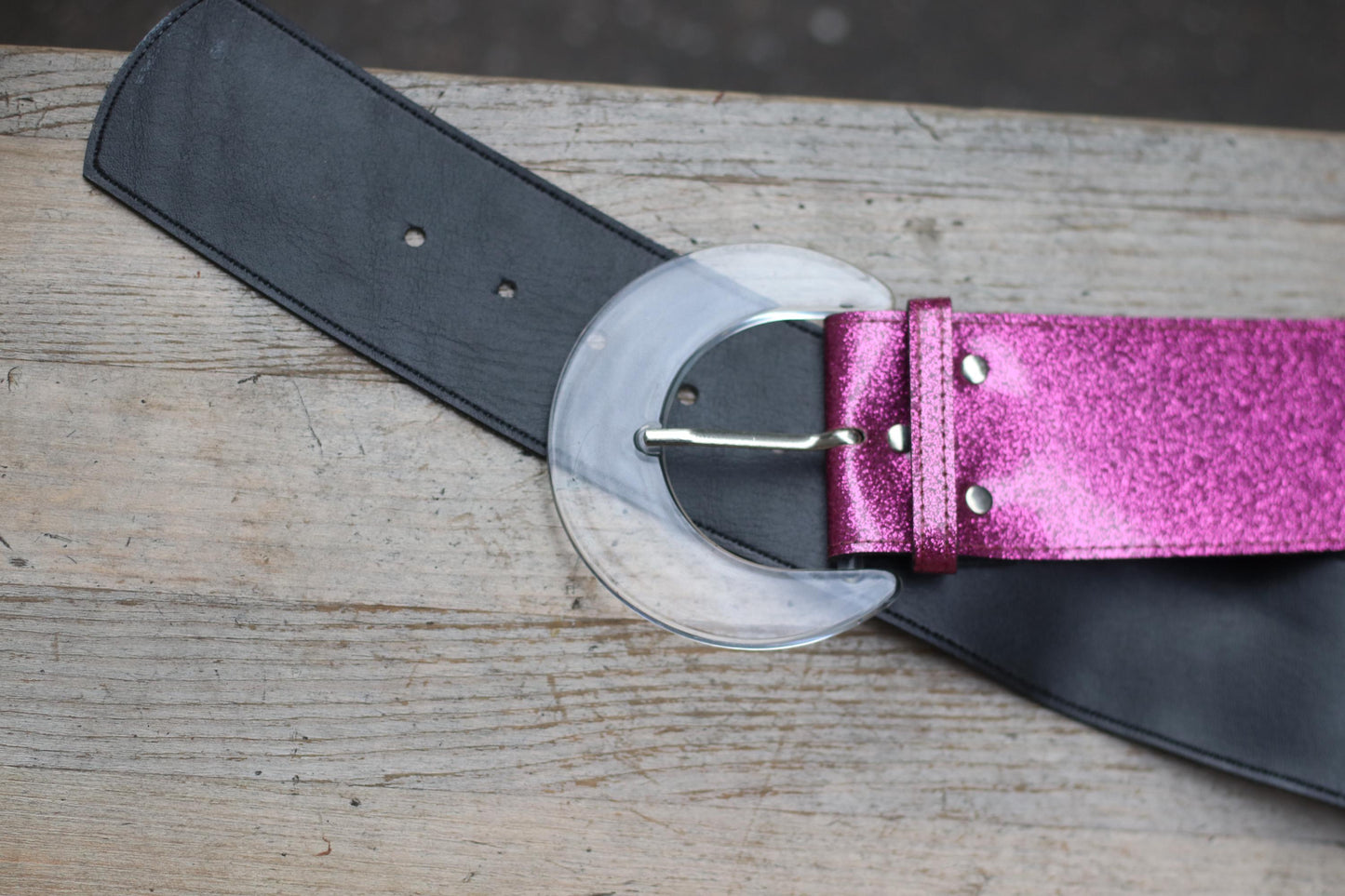 Close-up of early 2000s belt featuring glitter strap and transparent acrylic buckle
