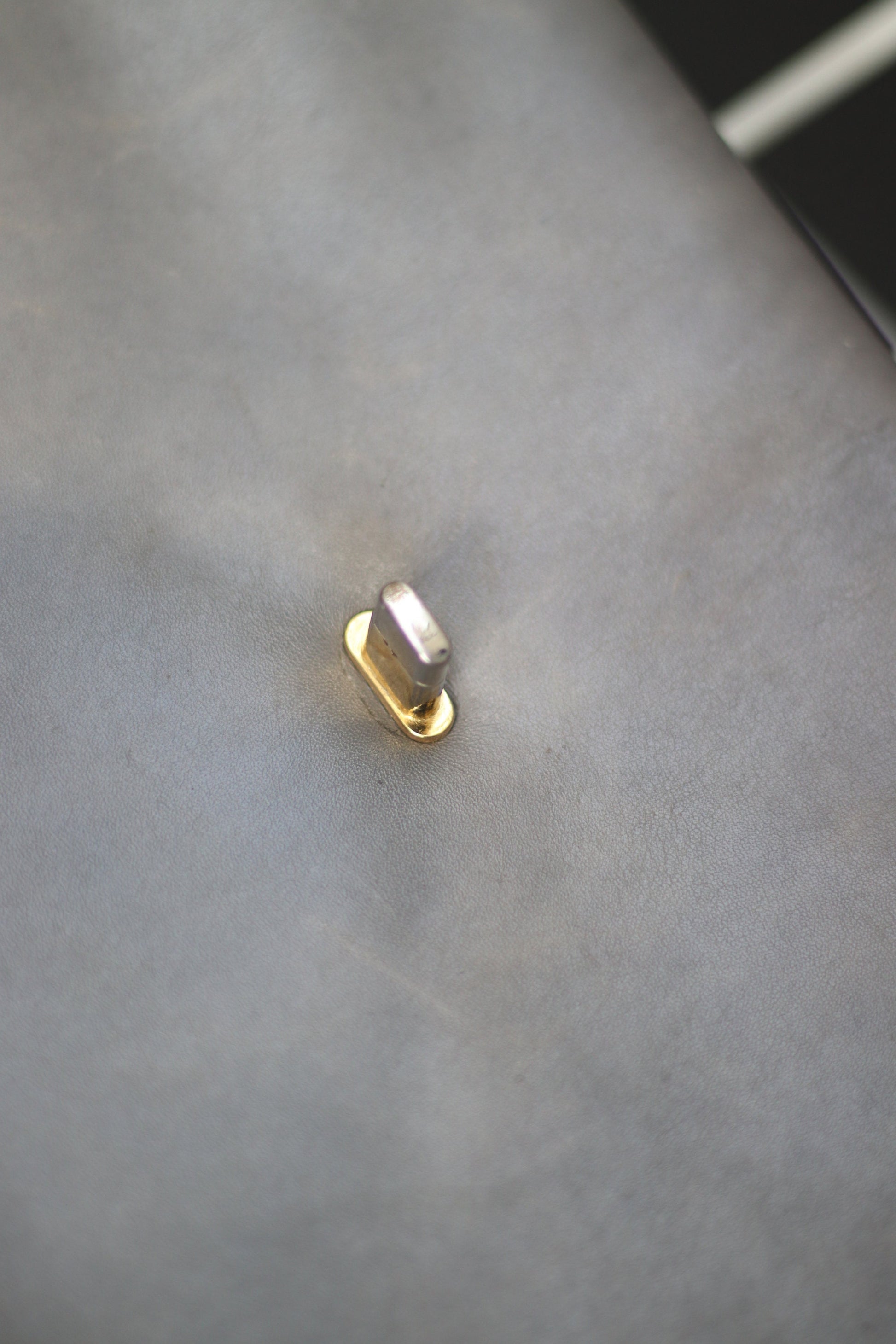Close up of the closure of a compact bag from the 70s photographed. The minimalist leather bag for women is by the german brand Nierhaus.