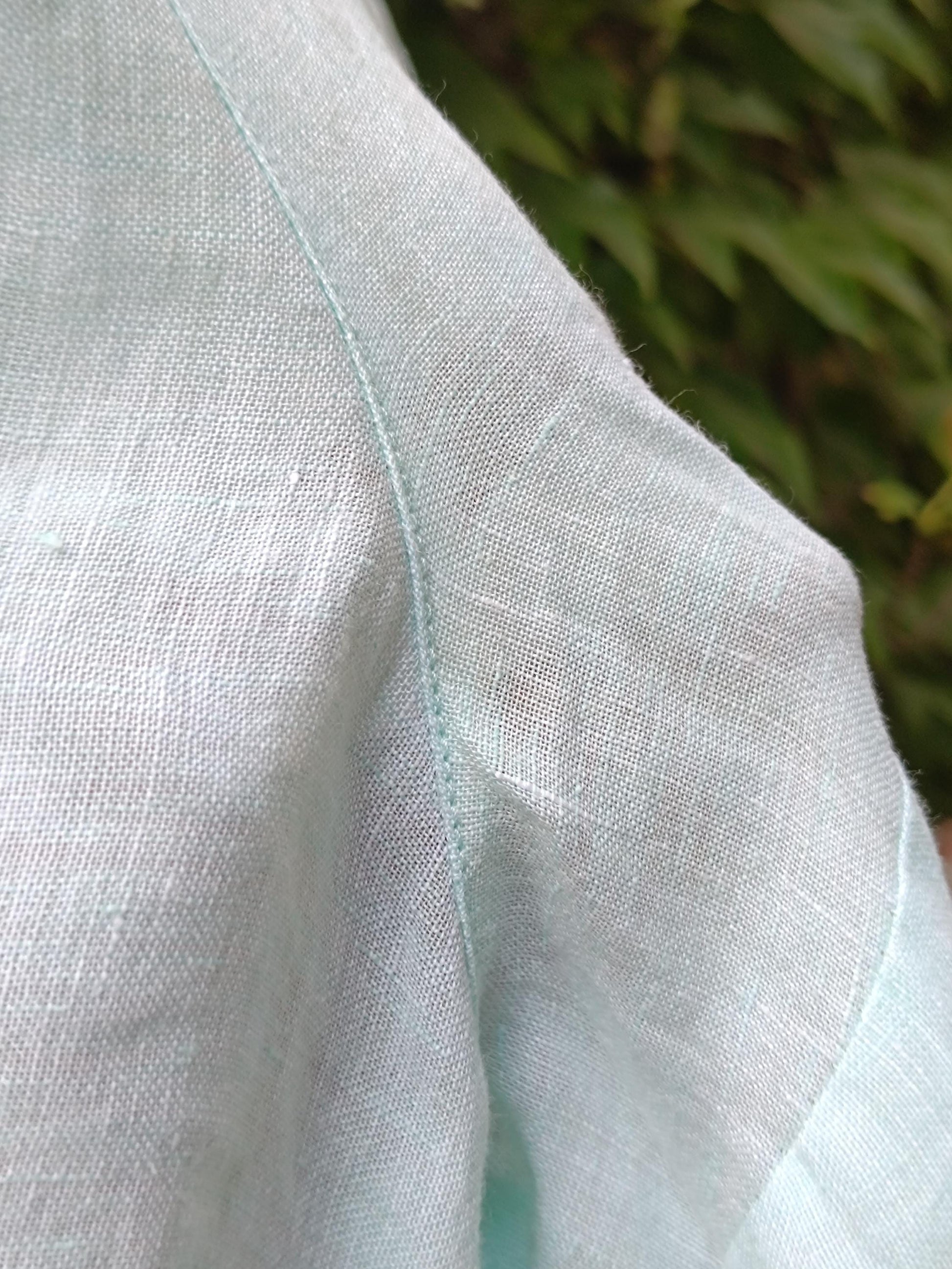 A zoomed in view of a 90s vintage light blue, relaxed-fit linen shirt to highlight the color and texture of the breezy summer design