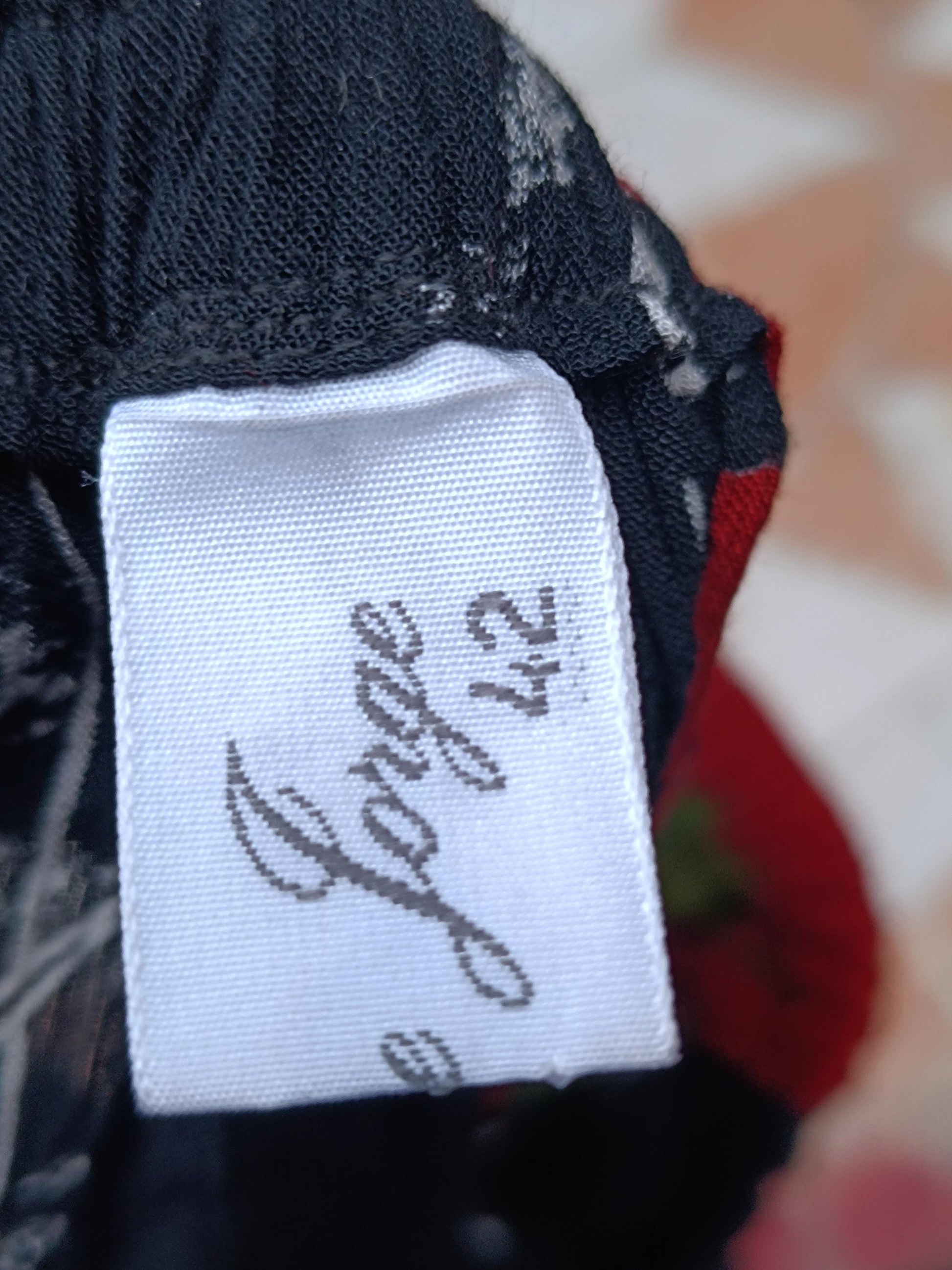 A zoomed in image of a white size tag of a Retro vintage floral maxi skirt.the tag reads Jorge 42