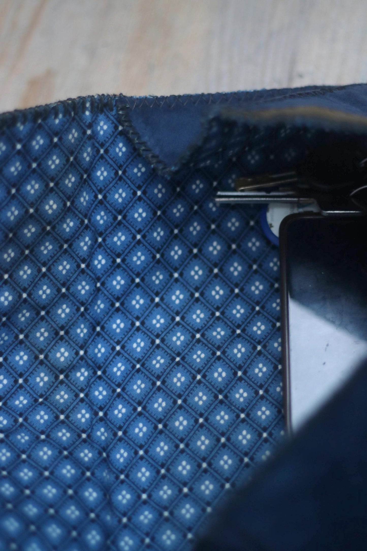 A close up of a  blue patterned lining of a vintage patchwork suede mini clutch