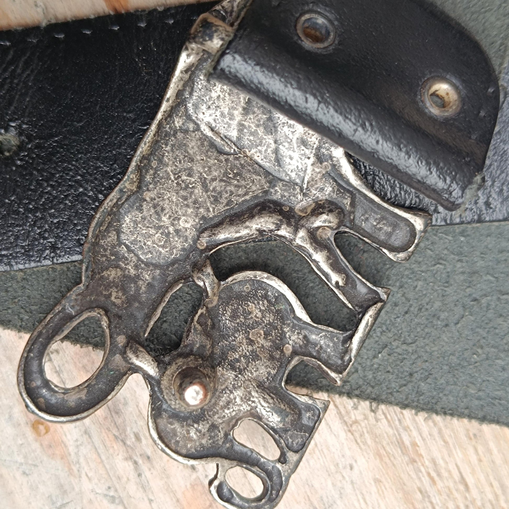 Zoomed-in view of the mystical elephant buckle on a vintage leather belt, highlighting the symbolic Indian craftsmanship