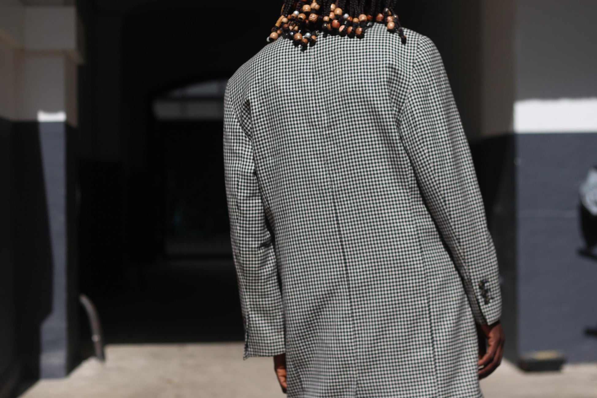 Back of the longline vintage 90s gingham blazer on s model showing the clean lines, tailored fit, and subtle shaping of the 80s-inspired silhouette
