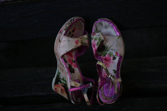 Vintage Y2K floral platform wedges with pink trim and bold flower print design by Young Spirit photographer against a dark background so the pink pops