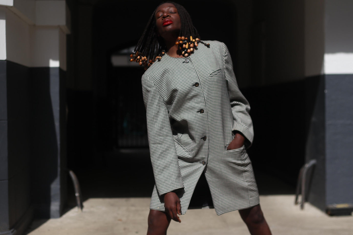 Model wearing a vintage gingham blazer as a dress, buttoned up and paired with boots, showing its versatility as both outerwear and standalone outfit.