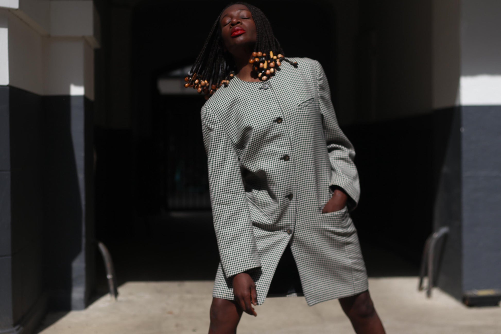 Model wearing a vintage gingham blazer as a dress, buttoned up and paired with boots, showing its versatility as both outerwear and standalone outfit.