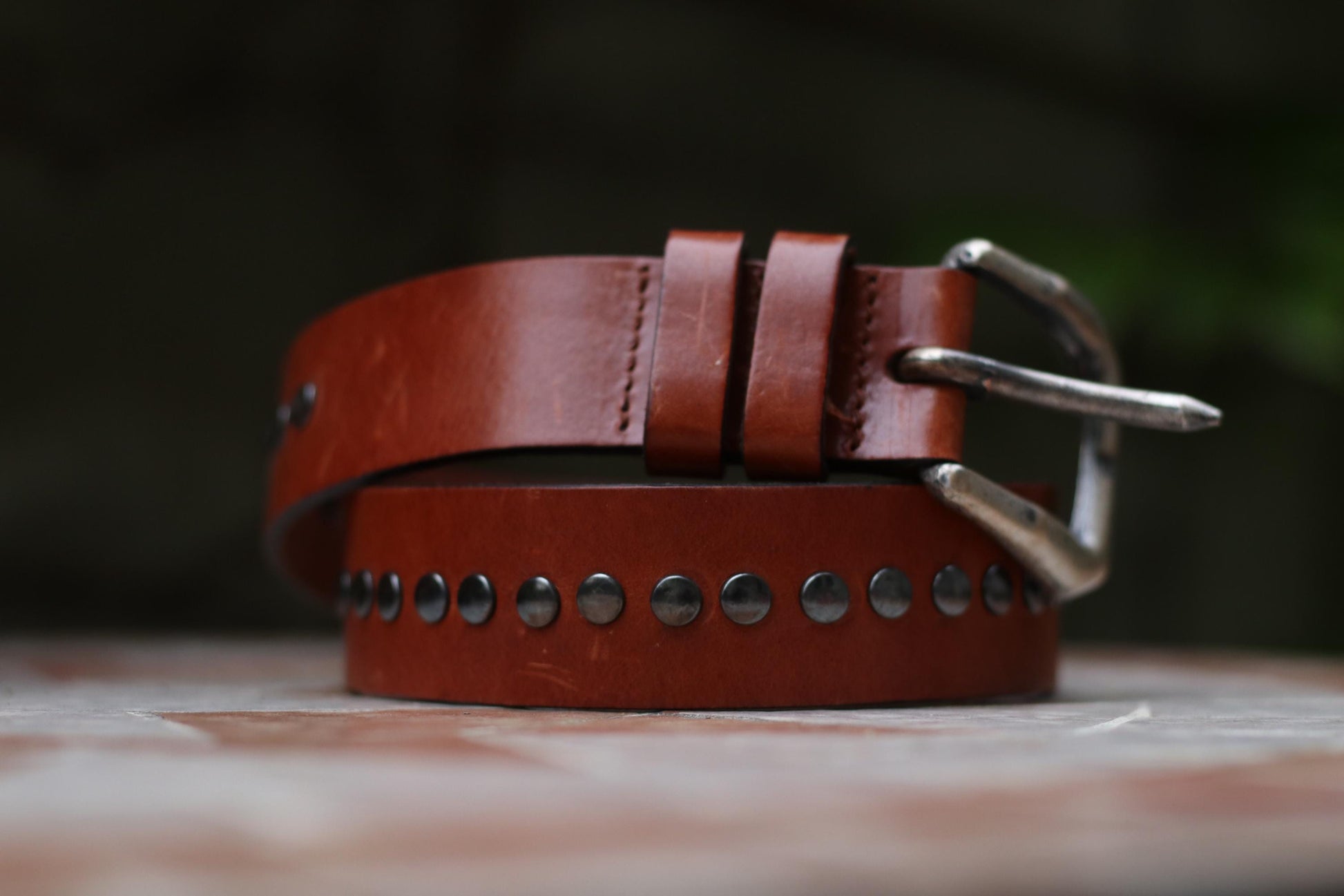 A vintage Western-style leather belt with metal stud embellishments and a silver-toned buckle.