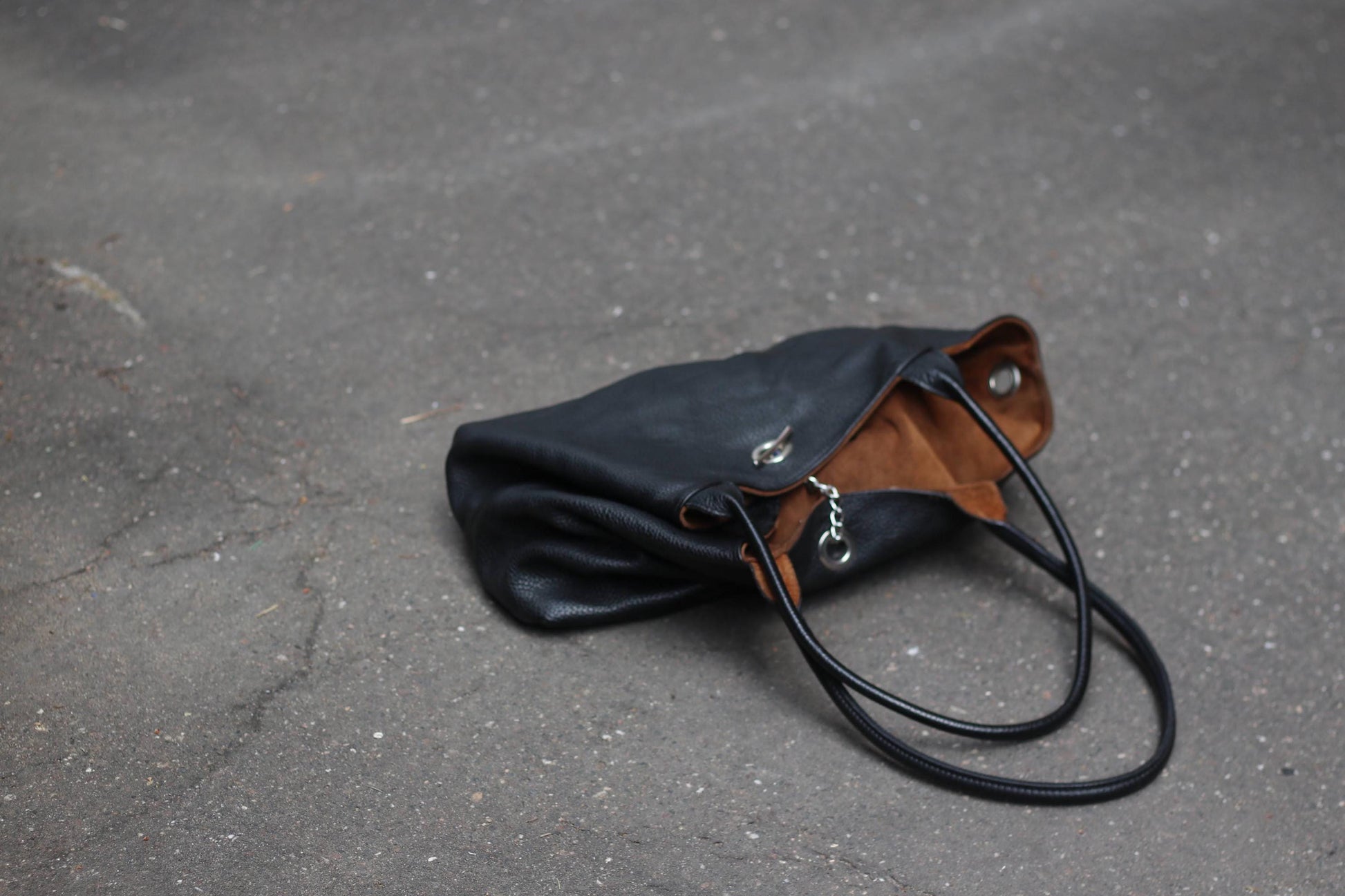 Stylish large black hobo-style bag made of leather, shown on a dark ground.