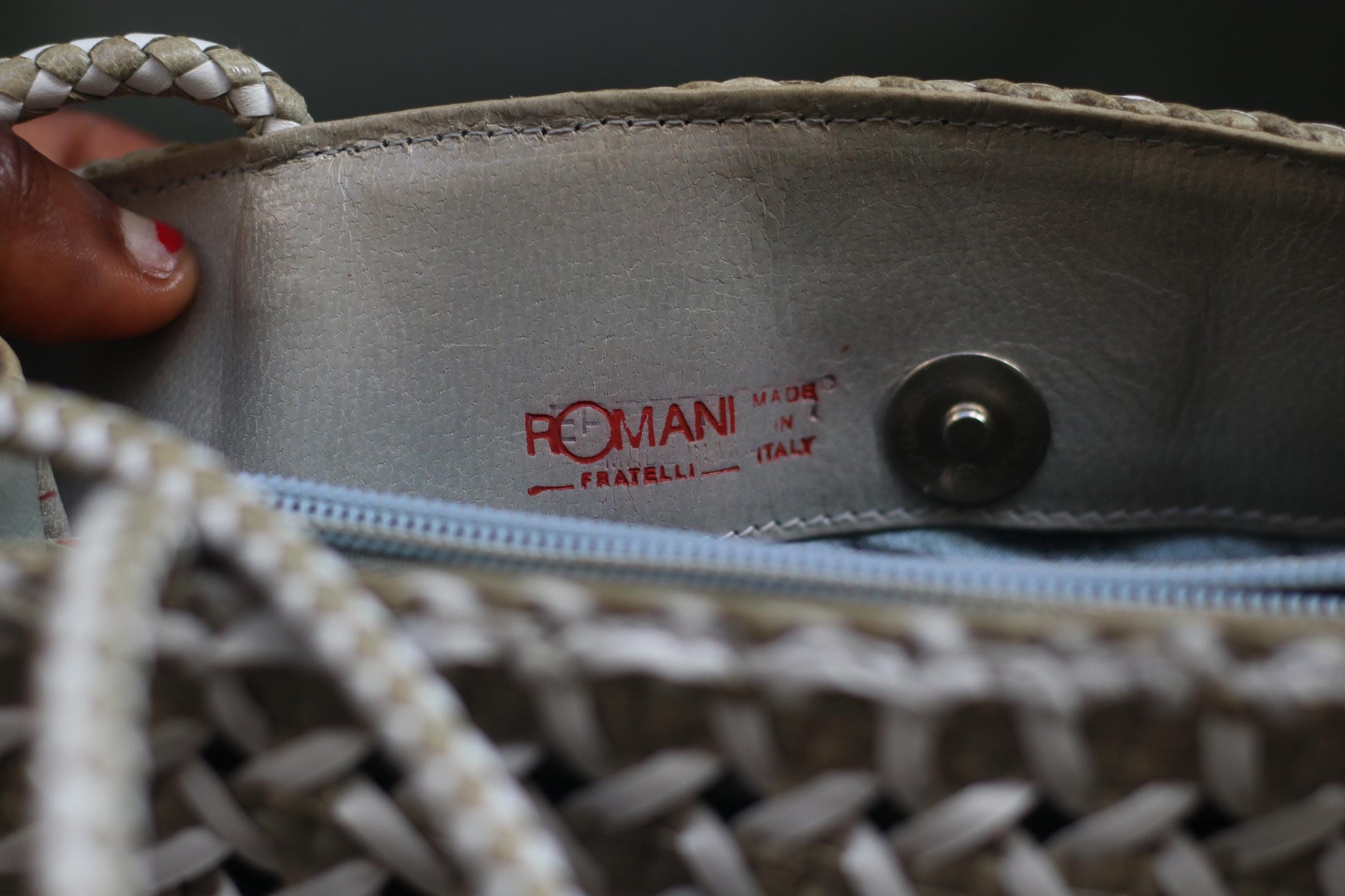 Inside of a  White leather woven bag by the following is visible in red lettering:  Romani Fratelli Italy